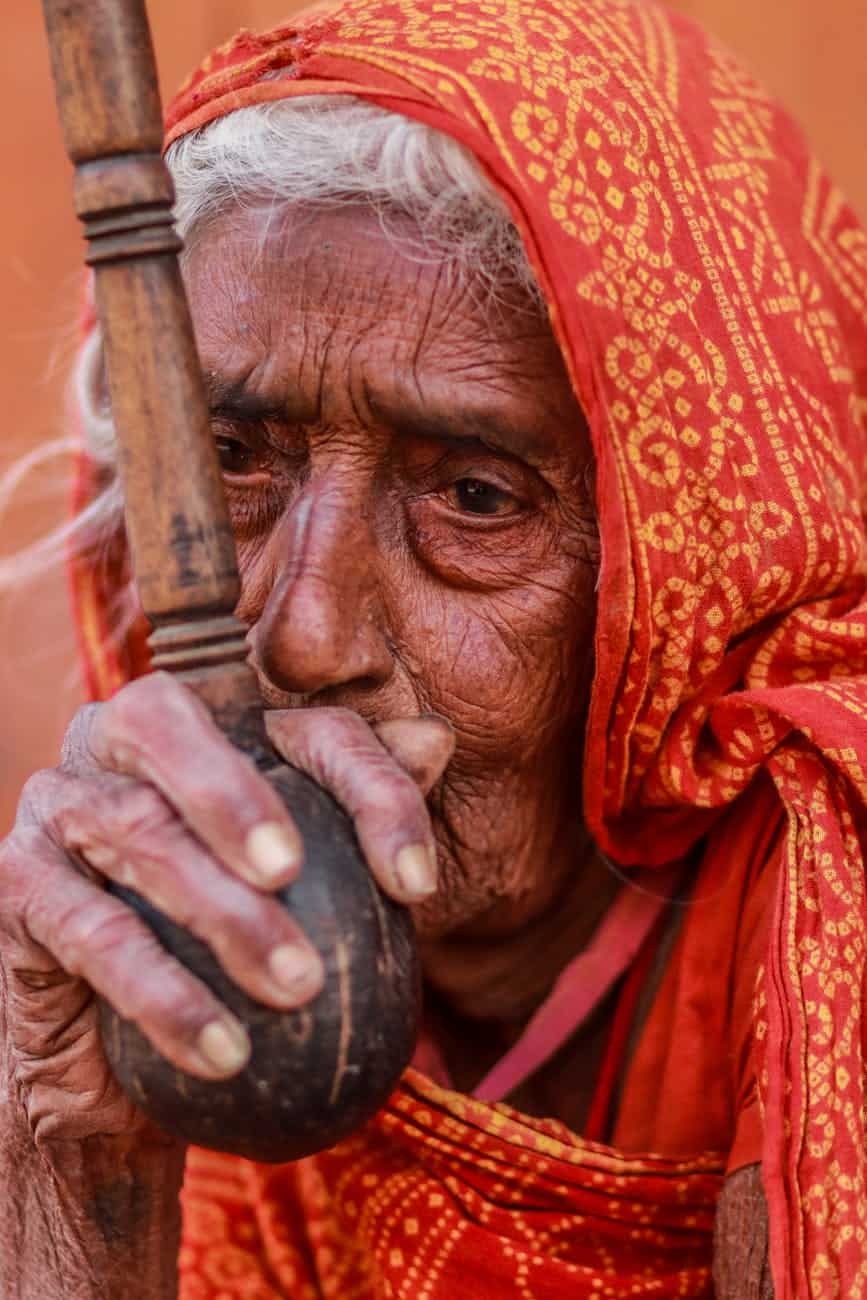 woman in orange veil holding brown pipe