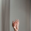 anonymous woman performing dance with raised arms in studio