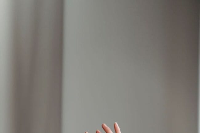anonymous woman performing dance with raised arms in studio