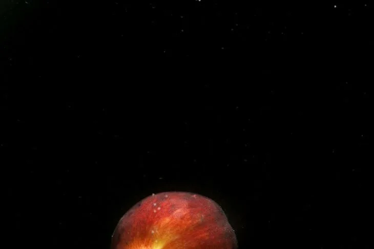 photo of a peach on top of an orange smoke