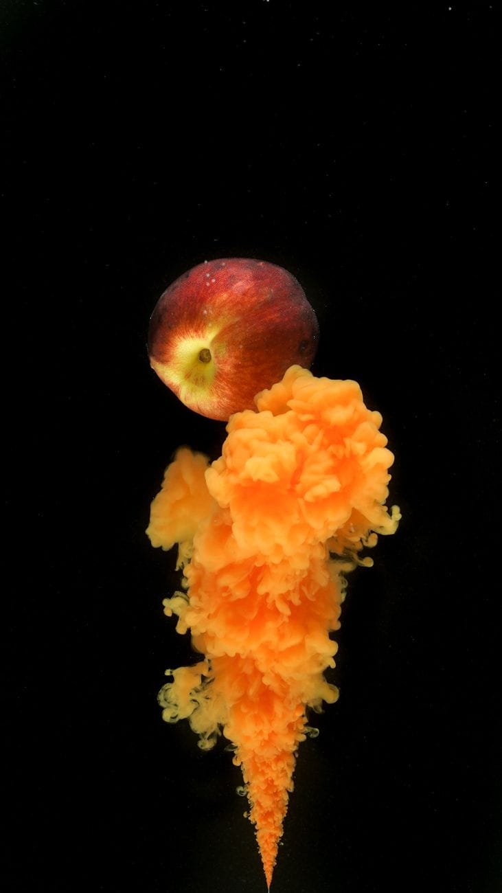 photo of a peach on top of an orange smoke
